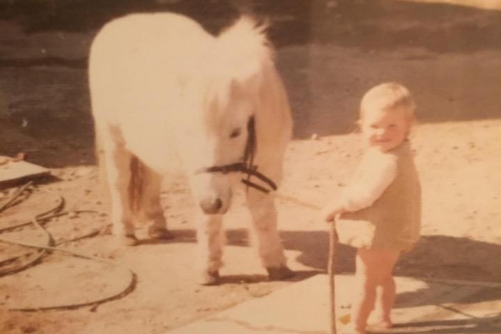 a boy standing next to a dog