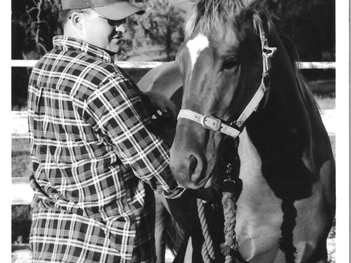 a group of people standing next to a horse