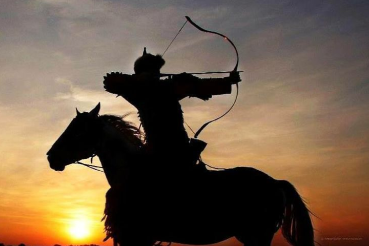 a person riding a horse in front of a sunset