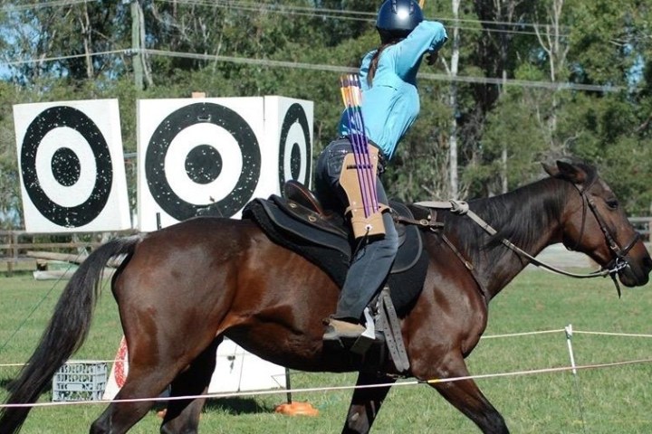 a person riding a horse in front of a fence