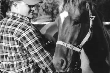 a person standing next to a horse